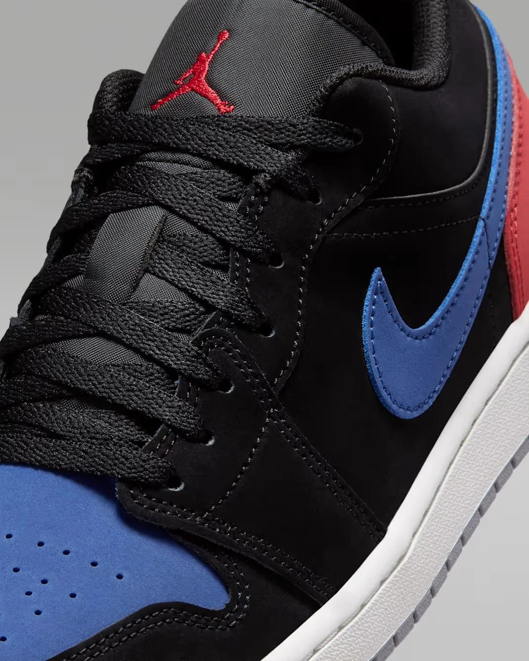Close-up of the True Blue Nike Swoosh on the Air Jordan 1 Low Black True Blue Varsity Red Summit White.